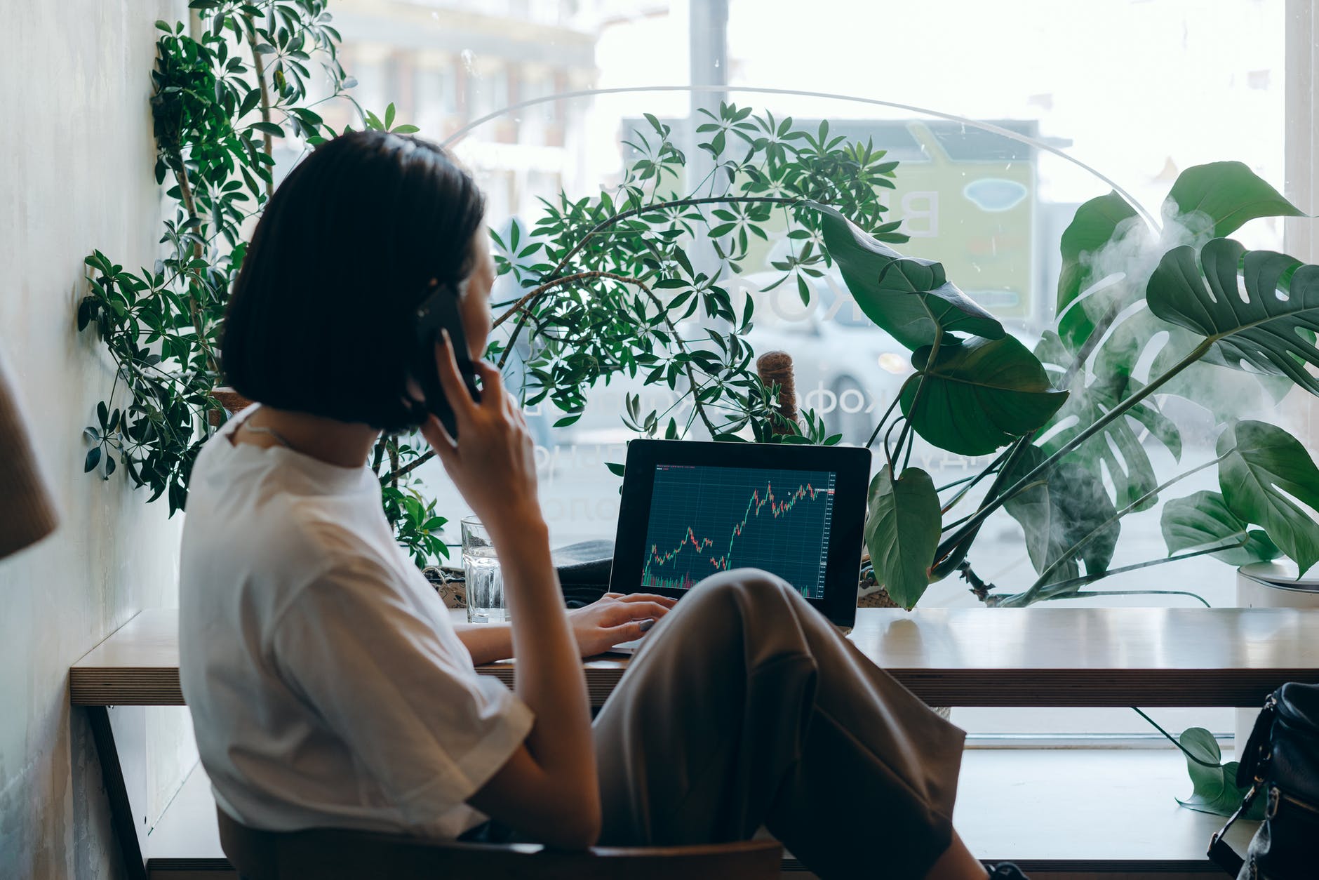 businesswoman in white shirt sitting on chair while having phone call